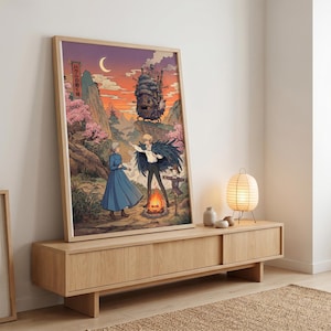 May include: Framed art print featuring a scene from a Japanese animated film. The artwork depicts characters in a mountain landscape with a castle, a bonfire, and cherry blossoms. The color palette includes shades of orange, blue, and pink.