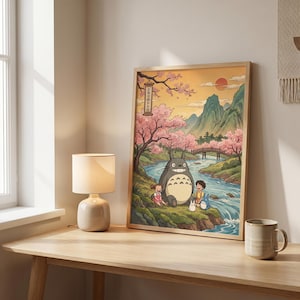 May include: A framed art print featuring a scene with a large gray creature, children, and a river. The artwork has a Japanese anime style, with cherry blossom trees, mountains, and a bridge. The text in the image is in Japanese.