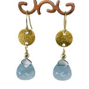 Puede incluir: Pendientes de oro con un disco redondo texturizado y una piedra preciosa de topacio azul en forma de lágrima.