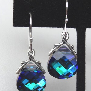 May include: A pair of silver dangle earrings with teardrop-shaped blue and green crystal stones.