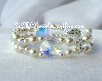 May include: A double-strand bracelet featuring white pearls and clear crystal accents. The bracelet has a silver clasp and is accented with small silver spacers set with clear rhinestones.