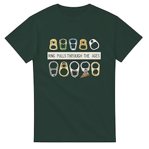 Puede incluir: Una camiseta de manga corta de color verde oscuro con un estampado gráfico de varios anillos de apertura de latas de metal dispuestos en dos filas. Entre las filas, el texto "RING PULLS THROUGH THE AGES" está impreso en letras mayúsculas negras.