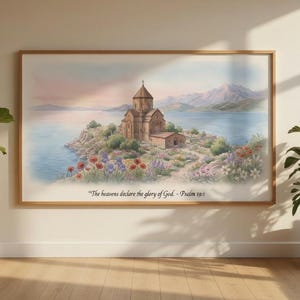Może przedstawiać: Oprawiony wydruk akwarelowy przedstawiający kościół na małej wyspie, otoczony wodą i górami. Grafika charakteryzuje się miękkimi kolorami i tekstem "Niebiosa głoszą chwałę Boga - Psalm 19:1". Dwie rośliny doniczkowe flankują grafikę.
