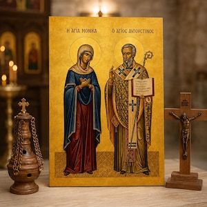 Op de afbeelding: Een rechthoekig religieus icoon op een gouden achtergrond met de heilige Monica en de heilige Augustinus. De heilige Monica draagt een blauw en rood gewaad, terwijl de heilige Augustinus versierde gouden gewaden draagt, een staf en een open boek met Griekse tekst vasthoudt.