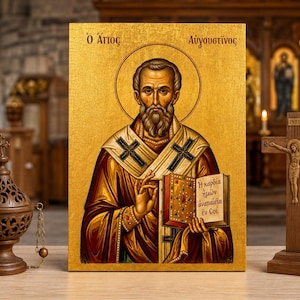 Może przedstawiać: Prostokątna ikona religijna przedstawiająca brodatego świętego w złotych szatach trzymającego księgę z greckim tekstem, otoczona ciemnobrązowym, ozdobnym metalowym kadzielnicą po lewej stronie i drewnianym krucyfiksem z literami INRI po prawej.