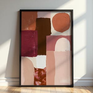 Puede incluir: Una pintura abstracta enmarcada que muestra la cara de un gato asomándose tras formas geométricas texturizadas en tonos terracota, burdeos intenso, marrón oscuro y rosa suave, incluyendo un círculo grande y un semicírculo.