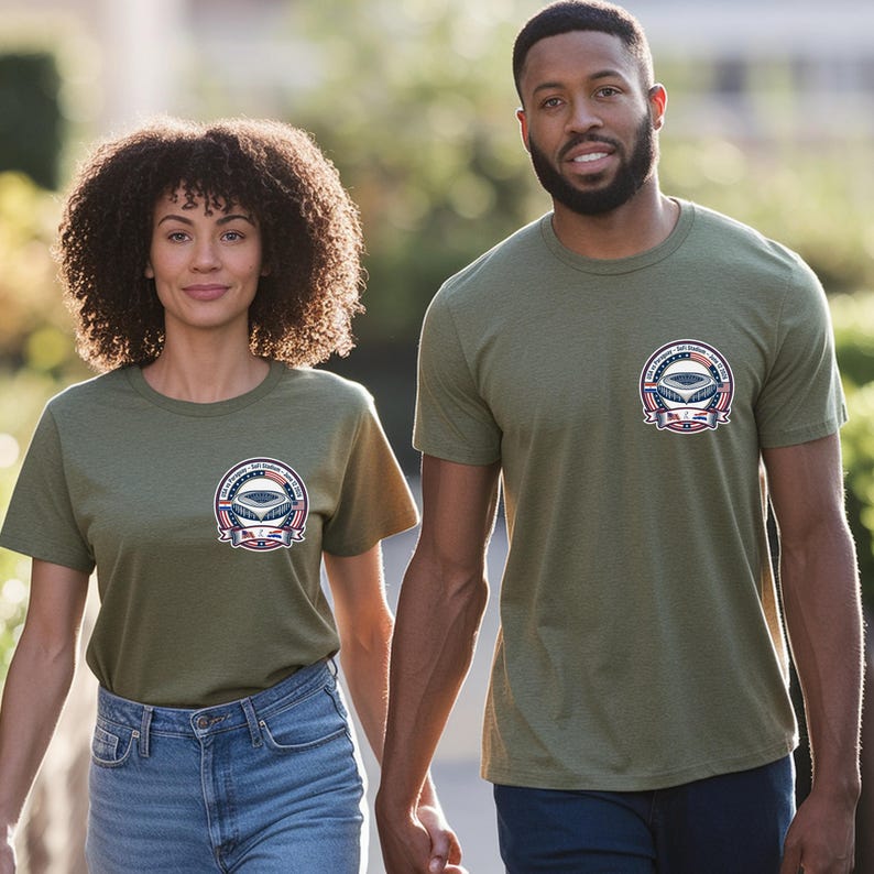 Man and woman walking outdoors wearing matching olive green t-shirts with a small chest logo featuring a USA vs Paraguay soccer stadium badge design. Casual summer outfit styled with jeans, showcasing comfortable unisex sports fan apparel perfect for soccer lovers, game day outfits, and everyday wear.