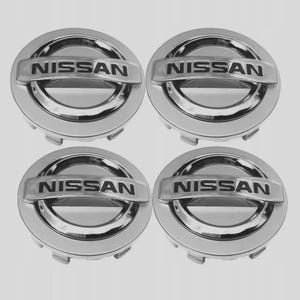May include: Four chrome Nissan hubcaps. Each hubcap is circular with the word "NISSAN" in a raised, silver bar across the center. The hubcaps have a shiny, reflective surface and are set against a light gray background.