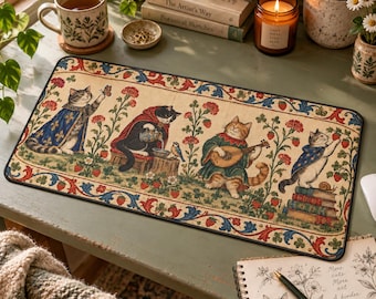 May include: A rectangular desk mat featuring a repeating border of red strawberries and blue leaves. The central illustration depicts four cats in medieval-style clothing: one reaching for a butterfly, one pouring water, one playing a lute, and one standing on a stack of books.