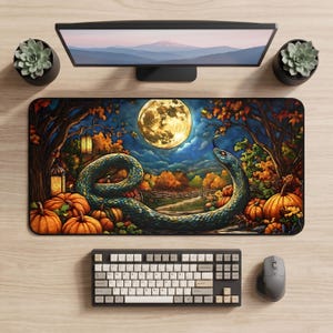May include: A rectangular desk mat featuring a vibrant autumn scene with a large, coiled green snake, a glowing full moon, orange pumpkins, and trees with fall foliage. The illustration includes two lanterns and a path leading into the distance.