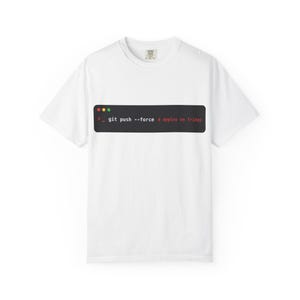 May include: A white short-sleeved t-shirt featuring a black rectangular graphic on the chest. The graphic mimics a computer terminal window with three colored dots and the white text "git push --force" followed by "# deploy on friday" in red.