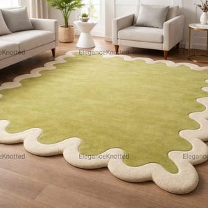 Wollen tapijt met geschulpte rand, olijfgroen en crème handgetuft vloerkleed, funky tapijt met golvende rand, esthetisch saliegroen decor, op maat gemaakt coquilletapijt.