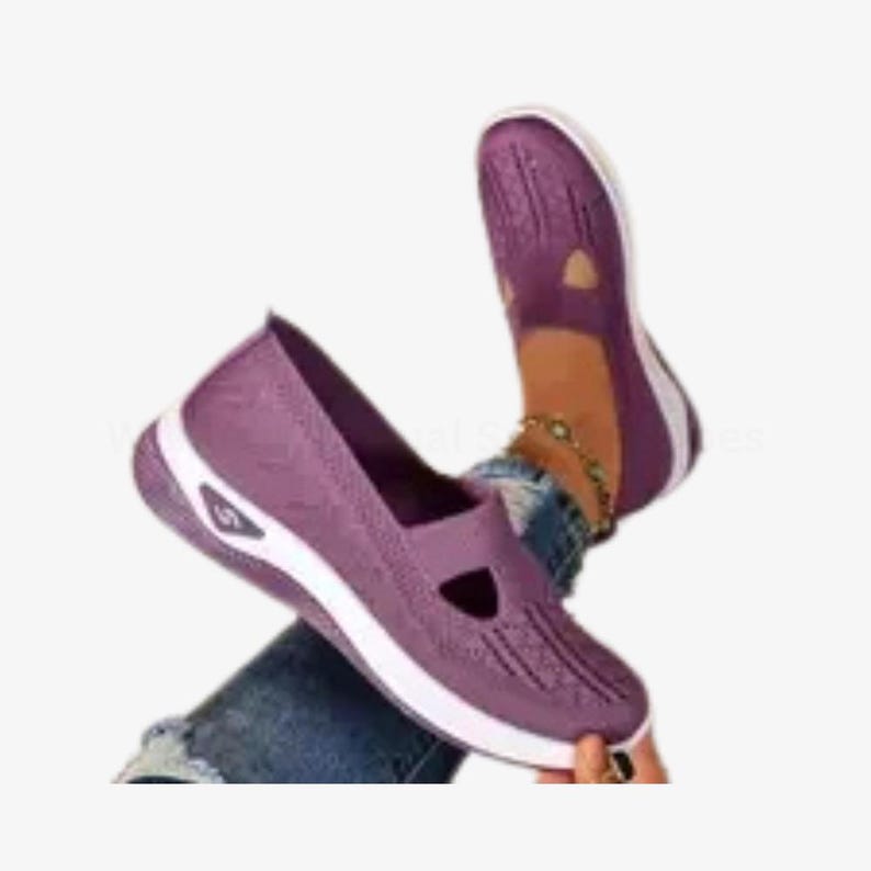 May include: Purple slip-on shoes with a white sole. The shoes feature a textured upper and a cut-out design. The image shows the shoes on a person's feet.
