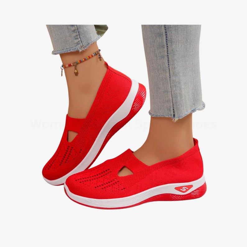 May include: Red slip-on trainers with white soles. The shoes feature a breathable knit upper and a small triangular cutout. The soles have a curved design with a small logo on the heel.
