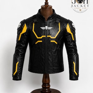 May include: A black leather jacket featuring yellow accents, a central front zipper, and a stand-up collar. The chest displays a white skull emblem with wings, while each shoulder features a white skull graphic. The jacket includes black buckles.