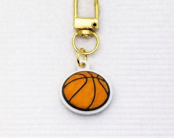 バスケットボール柄のジッパープル（2個セット）は、ジムバッグ、バックパック、ハンドバッグ、トートバッグなどにお使いいただけます。スポーツをテーマにした楽しいアクリル製ジュエリー＆ギフトです。