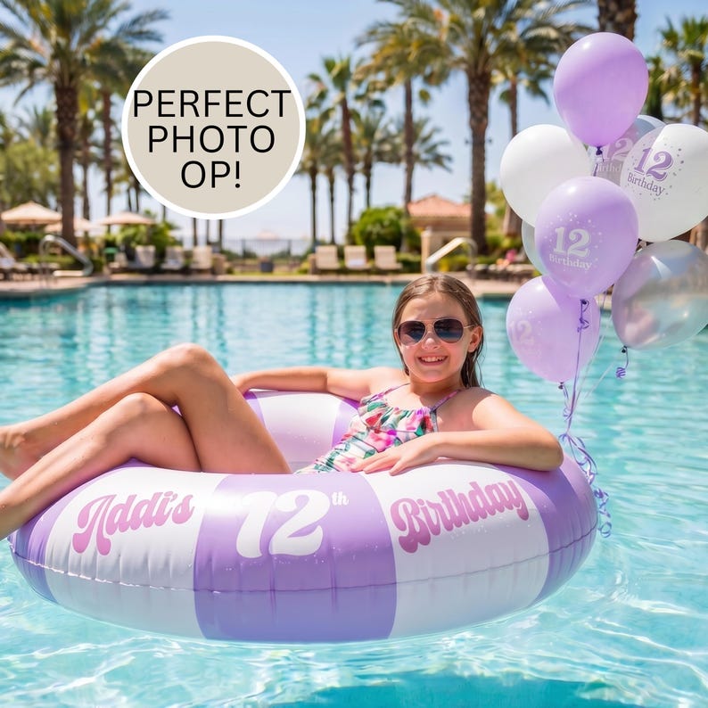 May include: A round inflatable pool float with alternating light purple and white stripes, featuring the text Addi's 12th Birthday. A cluster of purple, white, and silver balloons with the number 12 printed on them floats beside the pool ring.