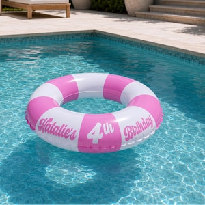 May include: An inflatable circular pool float featuring alternating pink and white segments. The surface is printed with the white text Natalie's 4th Birthday in a stylized font, positioned across the pink and white sections of the ring.