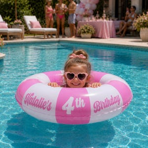 May include: A circular inflatable pool float with alternating pink and white stripes. The float features the white text "Natalie's 4th Birthday" printed across the front. The float is designed for use in water and is made of a smooth, durable material.