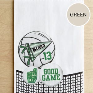 May include: White paper bag with a volleyball graphic, a green pennant that says "Bears" and the number "13". Two round buttons say "Good Game" and "#1". The bag has a black net design at the bottom.