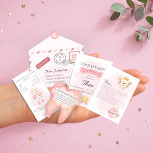 May include: A collection of tooth fairy items, including a receipt, certificate, and a tooth-shaped keepsake. The items are pink and white with text that reads "Tooth Fairy" and "Thea Johnson."