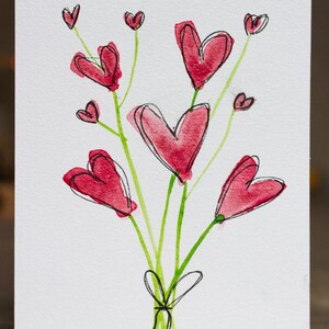 Puede incluir: Pintura a la acuarela de un ramo de flores rojas en forma de corazón con tallos verdes atados con una cinta negra. Los corazones tienen un efecto acuarela con contornos negros, sobre un fondo blanco.