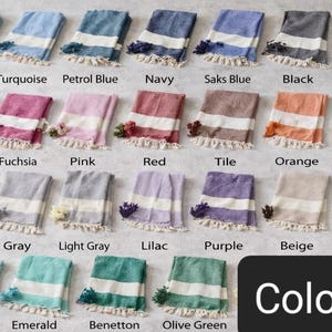 May include: A collection of colorful, folded Turkish towels, each with a white stripe and fringe. Colors include baby blue, turquoise, navy, black, brown, pink, red, orange, yellow, and more. The word "Colors" is displayed in a black rectangle.