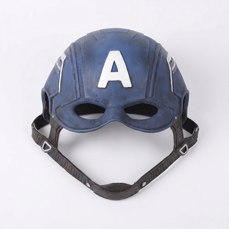 May include: A blue and white Captain America mask with the letter "A" on the front. The mask has a chin strap and eye holes. The mask is made of a durable material and is designed to fit the head.