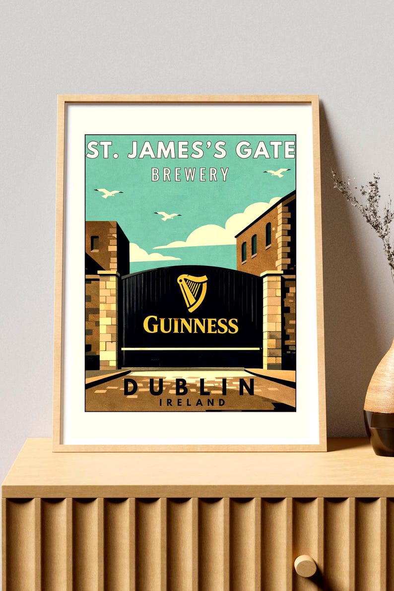 May include: Framed print of the St. James's Gate Brewery in Dublin, Ireland. The image features a black gate with the Guinness logo, set against a blue sky with seagulls. The brewery name and location are displayed.