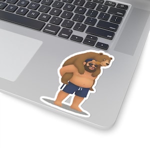 May include: A sticker featuring a cartoon illustration of a man carrying a brown bear on his back. The man is wearing blue shorts, a blue cap, and sunglasses. The bear is also wearing a cap. The sticker is on a laptop.