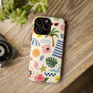 Puede incluir: Una funda de smartphone color crema con un patrón veraniego repetitivo. El diseño incluye ilustraciones de una palmera, una cámara instantánea rosa, una toalla de playa a rayas azules y blancas, rodajas de naranja, conchas, un hibisco y gafas de sol.