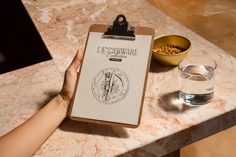 Może przedstawiać: Klip z tekstem "Dinnerware Collection" i ilustracją talerza. Mała złota miska z jedzeniem i szklanka wody znajdują się na marmurowej powierzchni. Klip jest trzymany przez osobę.