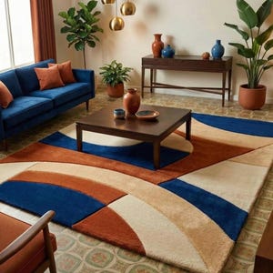 May include: A modern living room featuring a blue sofa with orange pillows, a dark brown coffee table, and a patterned rug. The rug has a geometric design with blue, orange, and cream colors. Decorative vases and plants add to the room's aesthetic.