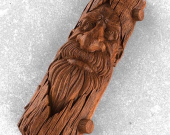 Può includere: Scultura in legno intagliato raffigurante il volto di un vecchio con una lunga barba. Il legno marrone mostra dettagli della venatura e della texture. Un'opera d'arte rustica e artigianale, ideale per l'arredamento.