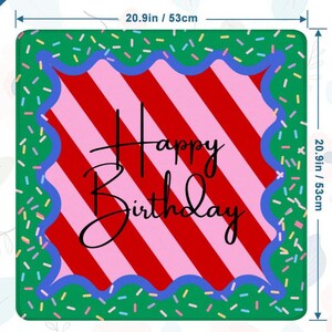May include: Square birthday mat, 20.9 inches (53cm) on each side. The mat features a red and pink striped center with the words "Happy Birthday" in black script. A blue scalloped border frames the center, set against a green background sprinkled with colorful confetti.
