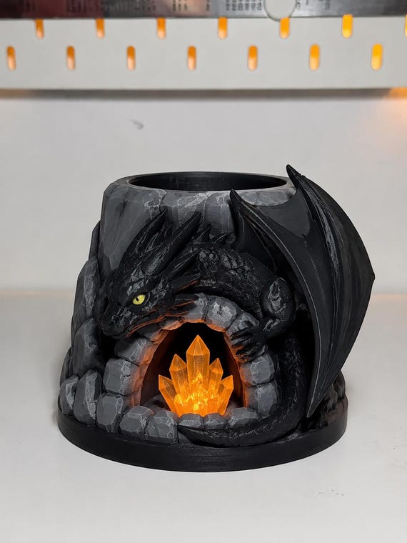 A hand-painted dragon coiled around a cave opening holds your pen like a fantasy artifact — resin-finished 3D printed sculpture that doubles as actual desk organizer.