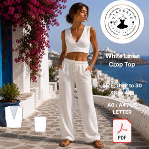 Op de afbeelding: Een vrouw draagt een witte linnen crop top en bijpassende broek met wijde pijpen. De outfit heeft een taille met trekkoord. De afbeelding bevat tekst: "White Linen Crop Top" en maat informatie. Een PDF-pictogram is ook zichtbaar.