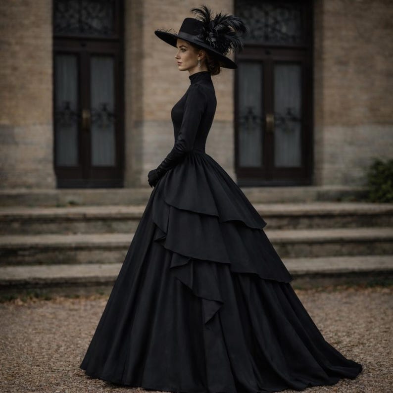 May include: A floor-length black gown with long sleeves, a high neckline, and a multi-layered, ruffled skirt. The ensemble includes a wide-brimmed black hat adorned with dark feathers, creating a cohesive, monochromatic appearance.