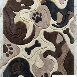 May include: A rectangular rug with a dog theme. The rug features a pattern of dog silhouettes, paw prints, and bones in shades of brown, beige, and black. The design is abstract and playful, suitable for a pet-friendly home.