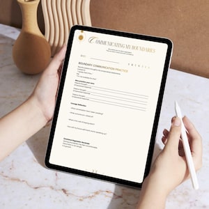 May include: A digital tablet displaying a "Communicating My Boundaries" worksheet. The worksheet has sections for boundary communication practice and courage reflection. A stylus is held near the screen. The background includes a wooden vase and decorative wooden shapes.