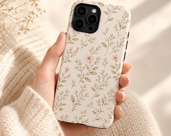 Könnte beinhalten: Eine Smartphone-Hülle mit cremefarbenem Hintergrund und einem wiederkehrenden Muster aus zarten botanischen Illustrationen, bestehend aus kleinen rosa Blüten, grünen Blättern und dünnen braunen Stielen, mit schwarzer Kameraaussparung.
