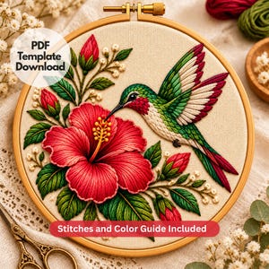 Puede incluir: Un bastidor de bordado con un panel de tela que muestra un diseño bordado de un colibrí sobre una gran flor de hibisco roja. El diseño incluye hojas verdes, capullos rojos y detalles florales blancos. El texto dice PDF Template Download.