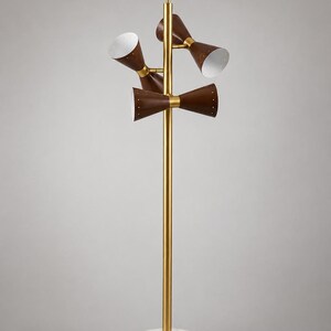 May include: A floor lamp with a central gold-toned metal pole and a circular white marble base. The lamp features three double-ended cone-shaped shades in a dark brown finish with white interiors, attached to the pole with gold-toned metal hardware.