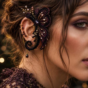 May include: A close-up of an ear adorned with a handcrafted ear cuff. The ear cuff features a dark purple and black butterfly design, embellished with gold accents, pearls, and a dangling teardrop-shaped gem. The intricate design suggests a gothic or fantasy theme.