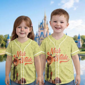 Puede incluir: Dos ni&ntilde;os con camisetas de b&eacute;isbol verde claro con un dise&ntilde;o de Nick Wilde. Las camisetas tienen ribetes blancos y el nombre "Nick Wilde" en letras naranjas. Un castillo se ve en el fondo.
