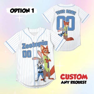 Peut inclure: Maillot de baseball blanc avec des fines rayures et des accents bleus. Il pr&eacute;sente le mot "Zootopia" et le num&eacute;ro "00" sur le devant, ainsi qu'une image de Judy Hopps et Nick Wilde. Le dos du maillot porte le texte "YOUR NAME" et le num&eacute;ro "00".