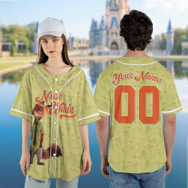 Puede incluir: Una camiseta de b&eacute;isbol verde claro con el personaje Nick Wilde de Zootopia. La camiseta tiene ribetes blancos, una parte delantera abotonada y el nombre "Nick Wilde" en escritura naranja. La parte trasera de la camiseta tiene el n&uacute;mero "00" en naranja.