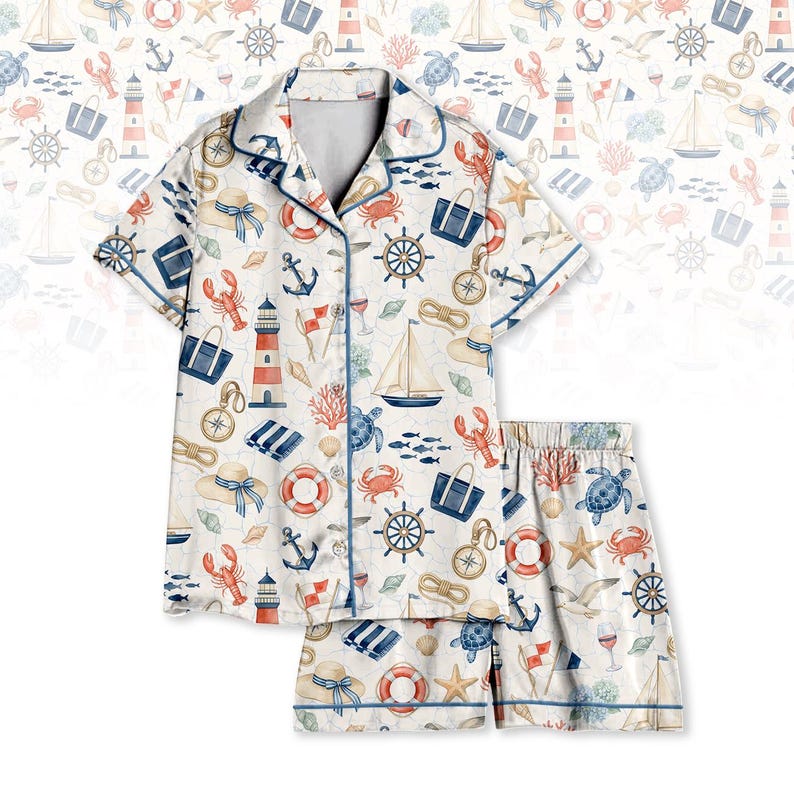 May include: White pajama set with a nautical pattern featuring anchors, sailboats, lighthouses, and sea creatures. The short-sleeved top and shorts have blue trim. The set is made of a soft, lightweight fabric.