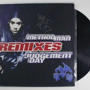 May include: A vinyl record with a black surface and a cover featuring Method Man. The cover has the words "Method Man Remixes Judgement Day" in red and white text. The cover also has a signature.