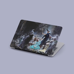 May include: A laptop featuring a skin with a dark, detailed painting of a group of figures in flowing garments, including a central figure in a dark cloak and others in blue, white, and yellow, set against a shadowy, cavernous background.